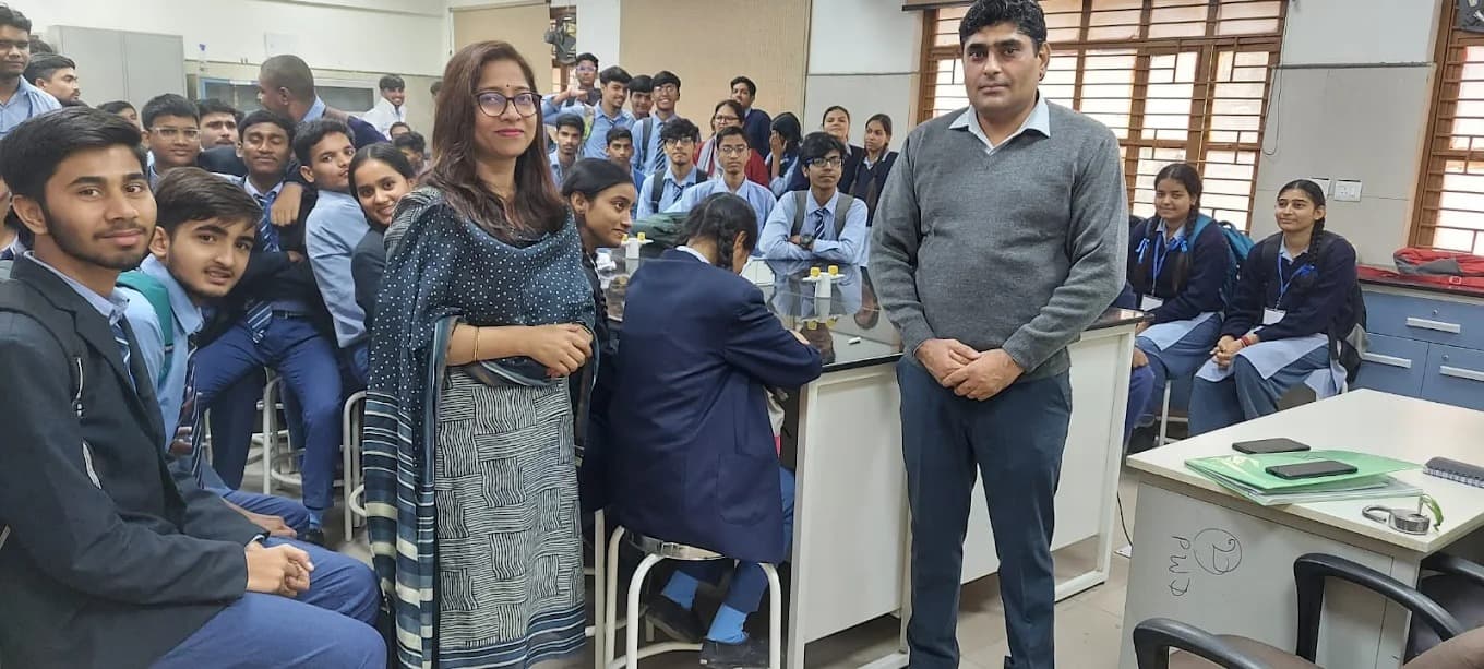 Two facilitators with a group of students inside a school science laboratory.